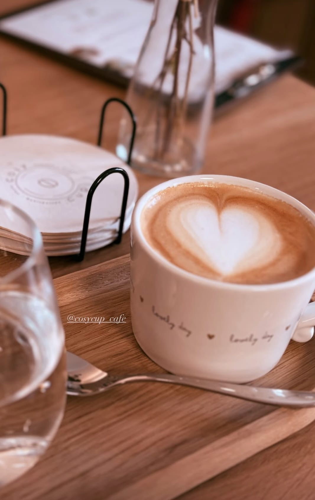 Cappuccino mit Milchschaumherz auf einem Holztisch im Cosy Cup